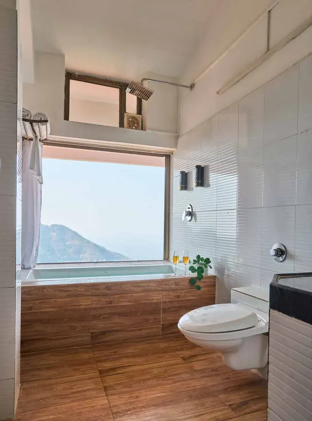 Bath tub beside a window onto the hills