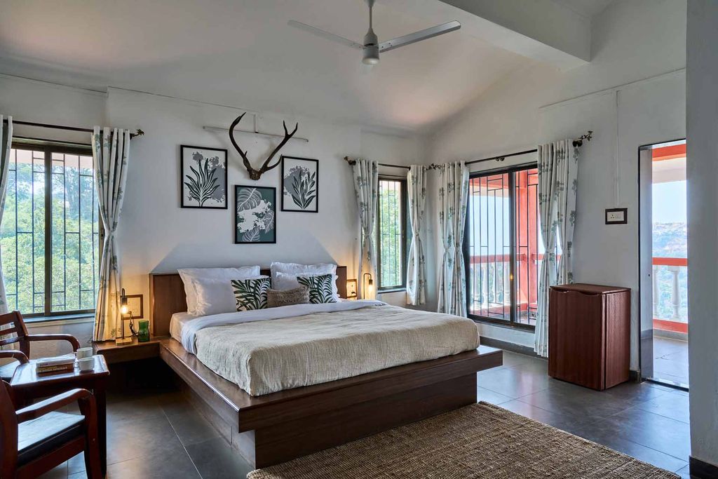 Bedroom with antlers, botanical prints and balcony door