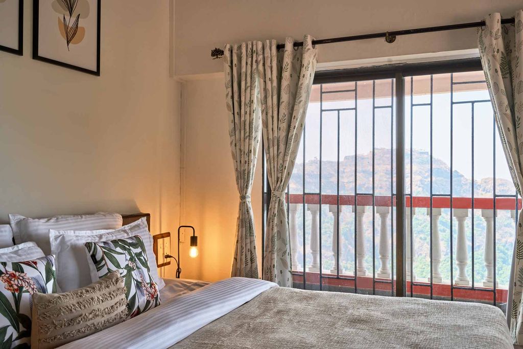 Bedroom window framing the forested hills