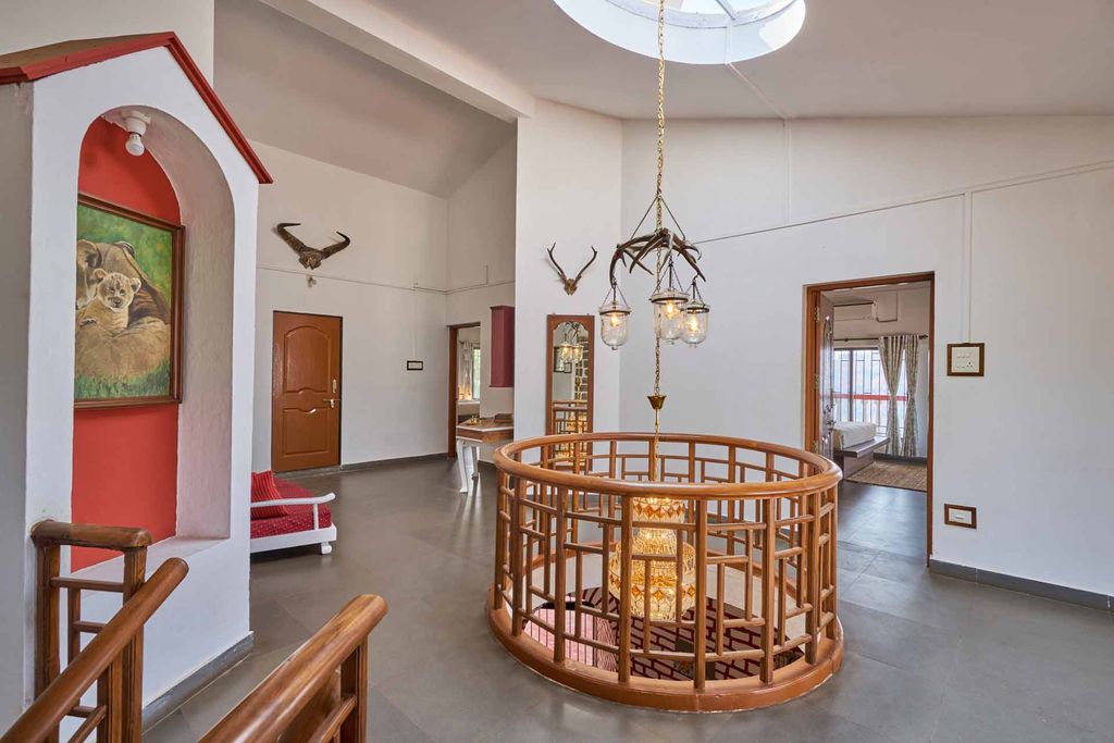 Upper landing with an antler chandelier above the round wooden railing